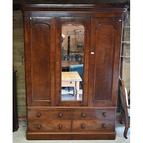 152 - A 19th century mahogany wardrobe with central arched mirror between panelled doors on a four drawer ... 