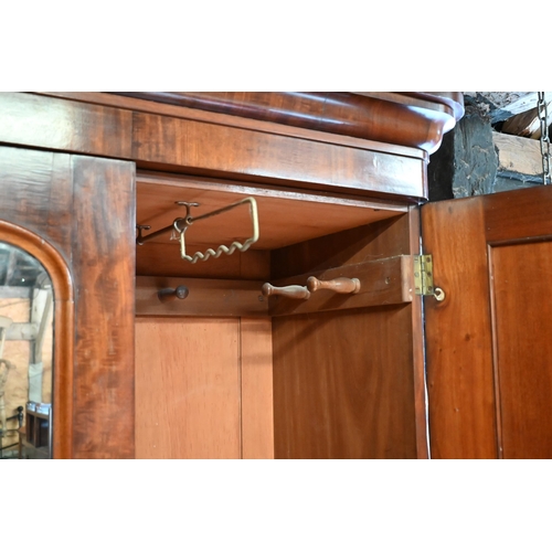 152 - A 19th century mahogany wardrobe with central arched mirror between panelled doors on a four drawer ... 