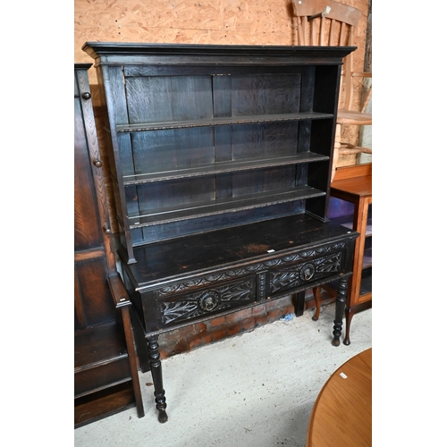 183 - A Gothic Revival carved oak dresser with plate rack and two drawer base with turned supports, 138 x ... 