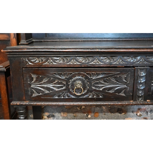 183 - A Gothic Revival carved oak dresser with plate rack and two drawer base with turned supports, 138 x ... 