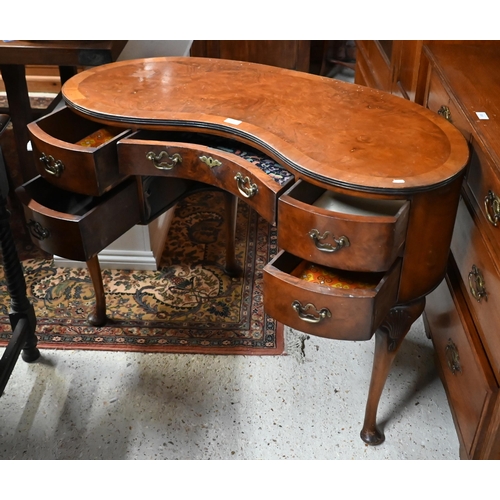 201 - A walnut crossbanded kidney shaped dressing table with five drawers on shell carved cabriole support... 