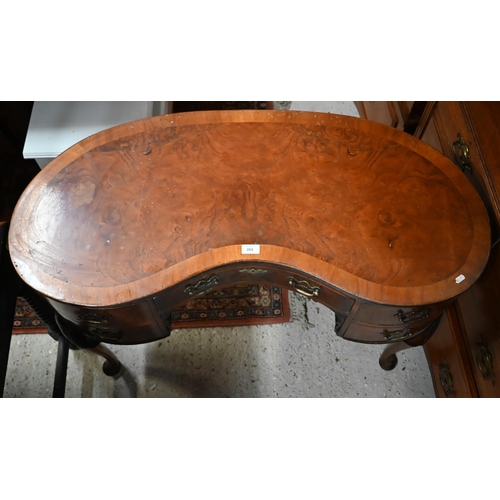 201 - A walnut crossbanded kidney shaped dressing table with five drawers on shell carved cabriole support... 