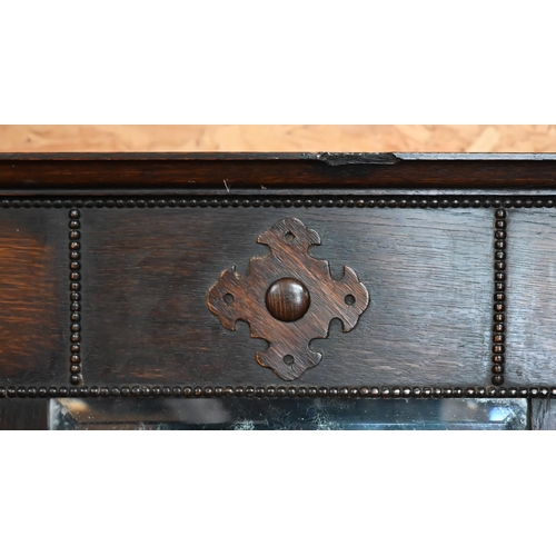 202 - A panelled oak hall bench, the raised back fitted with bevelled mirror and eight coat/hat pegs, 80 x... 