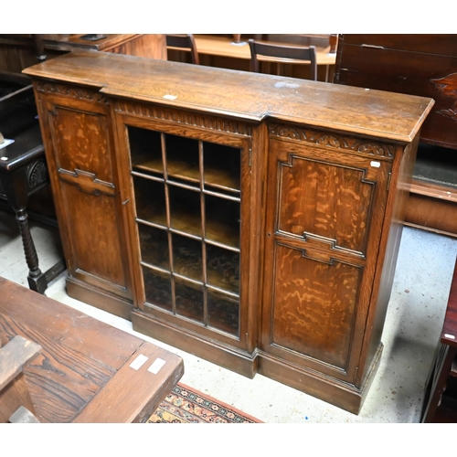 207 - An oak breakfront bookcase with glazed central door flanked by panelled cupboards on plinth base, 13... 