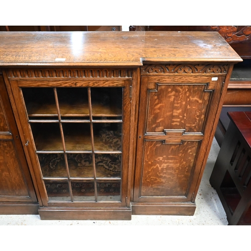 207 - An oak breakfront bookcase with glazed central door flanked by panelled cupboards on plinth base, 13... 