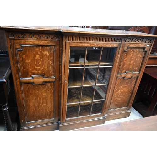 207 - An oak breakfront bookcase with glazed central door flanked by panelled cupboards on plinth base, 13... 