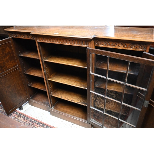 207 - An oak breakfront bookcase with glazed central door flanked by panelled cupboards on plinth base, 13... 