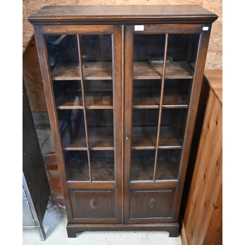 218 - An oak two door bookcase with glazed and panelled front, on bracket feet, 80 x 30 x 154 cm high