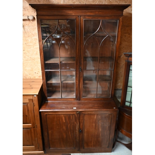 220 - A tall 19th century mahogany cabinet bookcase, the glazed top with two doors enclosing shelves over ... 