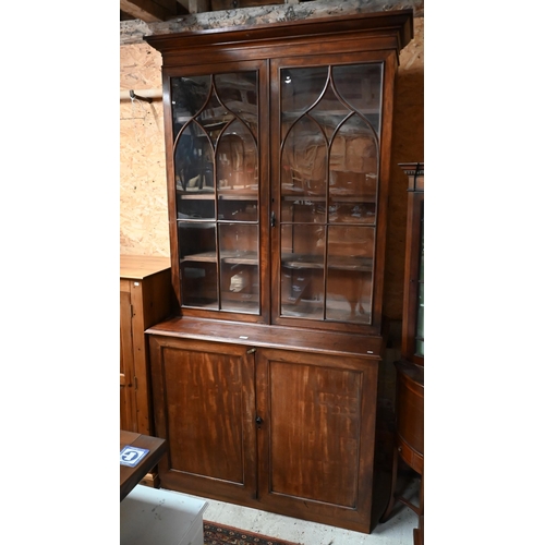 220 - A tall 19th century mahogany cabinet bookcase, the glazed top with two doors enclosing shelves over ... 