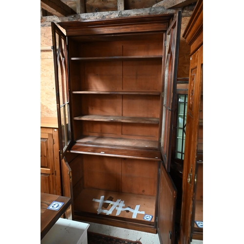 220 - A tall 19th century mahogany cabinet bookcase, the glazed top with two doors enclosing shelves over ... 