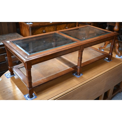 237 - # A modern coffee table with inset bevelled glass panels and rattan undertier, 130 x 55 x 40 cm high