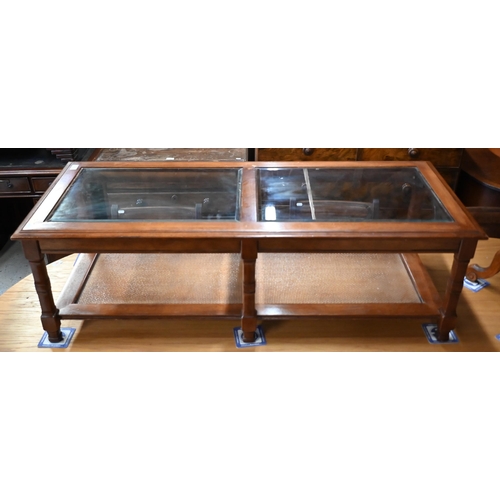 237 - # A modern coffee table with inset bevelled glass panels and rattan undertier, 130 x 55 x 40 cm high