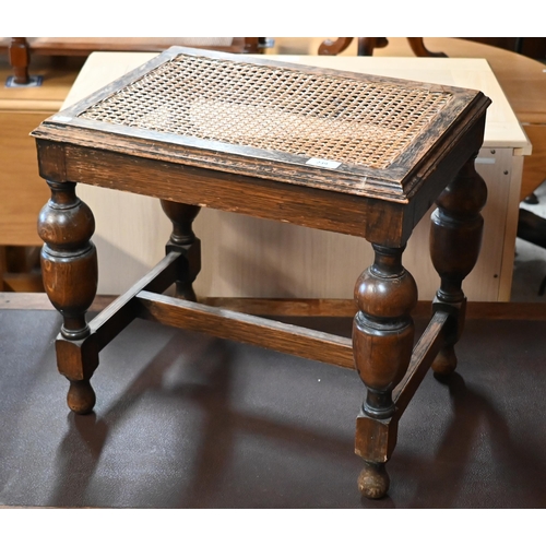 239 - # An early 20th century oak cane worked stool, on turned legs with stretchers, 50 x 40 x 45 cm high