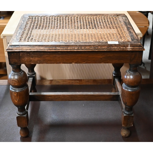 239 - # An early 20th century oak cane worked stool, on turned legs with stretchers, 50 x 40 x 45 cm high