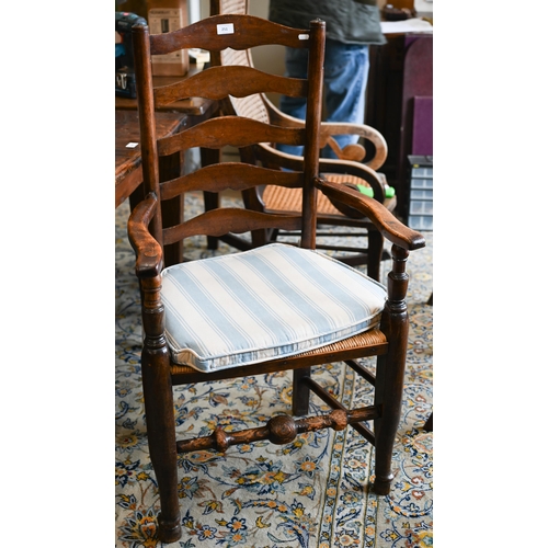 251 - A set of four provincial ash wavy ladderback dining chairs with rush seats, 3 standard and 1 carver ... 