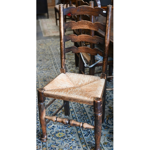 251 - A set of four provincial ash wavy ladderback dining chairs with rush seats, 3 standard and 1 carver ... 