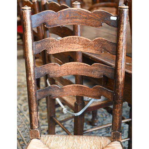 251 - A set of four provincial ash wavy ladderback dining chairs with rush seats, 3 standard and 1 carver ... 