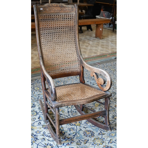 253 - An antique Continental rocking chair with caned back and seat, wooden frame with grained painted fin... 