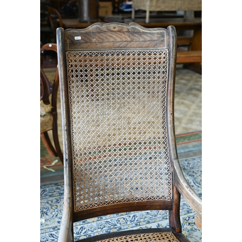 253 - An antique Continental rocking chair with caned back and seat, wooden frame with grained painted fin... 