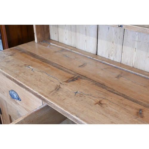 259 - An antique pine dresser two shelf plate rack on base with drawers over panelled cupboards, 110 x 46 ... 