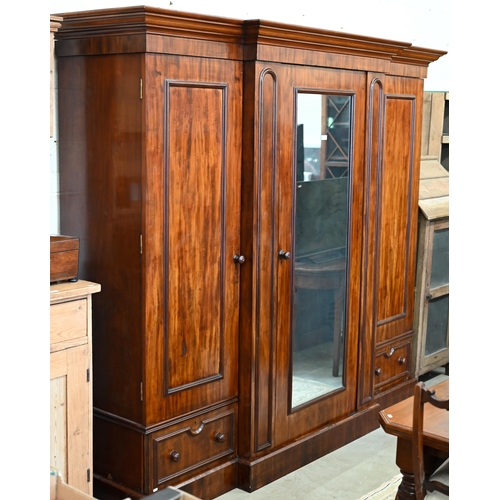 260 - A 19th century mahogany breakfront triple wardrobe, the central mirrored door flanked by panelled do... 