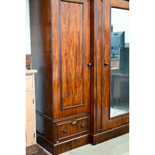 260 - A 19th century mahogany breakfront triple wardrobe, the central mirrored door flanked by panelled do... 