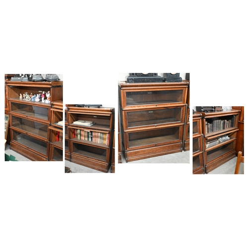Four oak Globe Wernicke library bookcases, the largest with four graduated glazed in sections, on a deep plinth base, 87 cm w x 142 cm h x 31 cm deep, the other three with three graduated sections, 115 cm h (4) one section with missing door, one door detached, all glass undamaged, good even surface colour