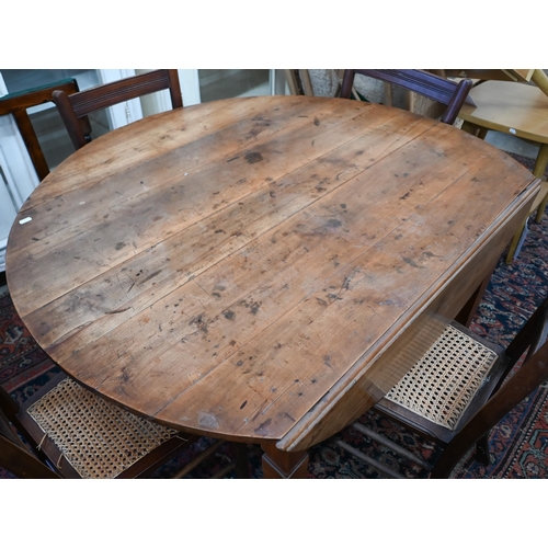 284 - # An antique continental cherry-wood drop leaf table, the circular top raised on shaped square legs,... 