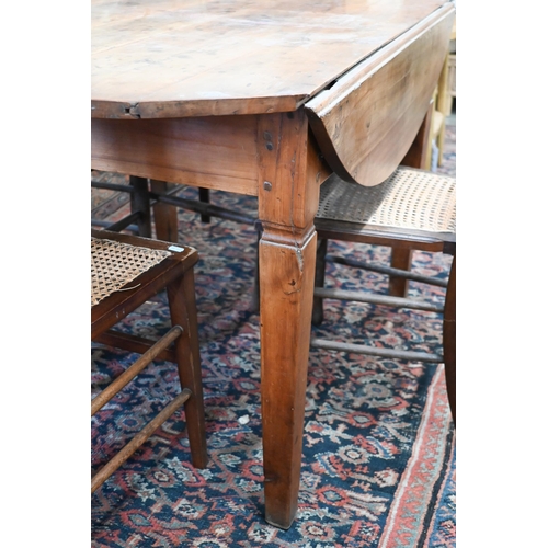 284 - # An antique continental cherry-wood drop leaf table, the circular top raised on shaped square legs,... 