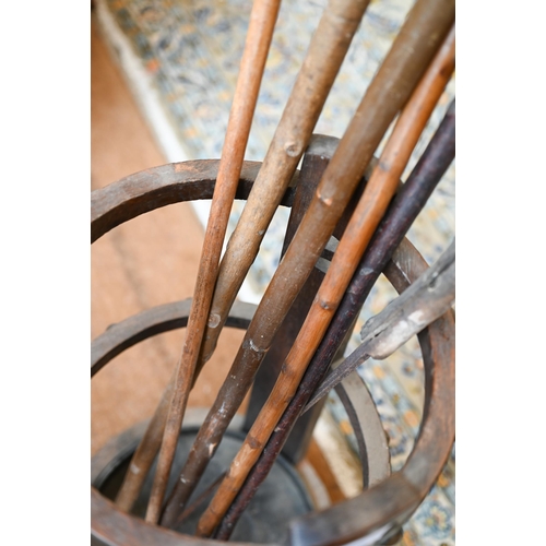 299 - An Arts & Crafts circular tapering open stick stand to/with sticks, 30 cm dia. x 73 cm h