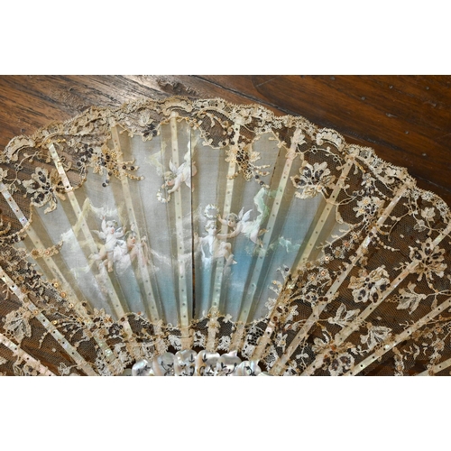 447 - An antique lace gauze fan, the central panel painted with cherubs, on decorated mother of pearl stic... 