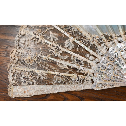 447 - An antique lace gauze fan, the central panel painted with cherubs, on decorated mother of pearl stic... 