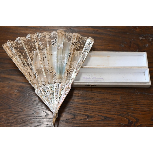 447 - An antique lace gauze fan, the central panel painted with cherubs, on decorated mother of pearl stic... 