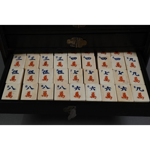 451 - An antique Chinese Mah Jong set with bone and bamboo tiles, in rosewood case with five drawers