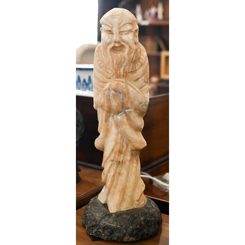 471 - An Asian carved stone figure of an elder, 49 cm high overall