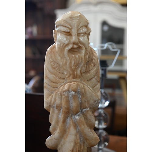 471 - An Asian carved stone figure of an elder, 49 cm high overall