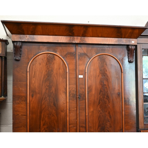 68 - A 19th century mahogany linen press (slides removed and replaced with two brass rails), with arch pa... 