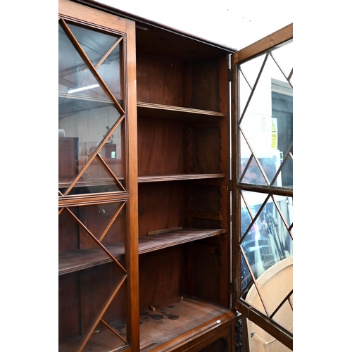 80 - A 19th century mahogany bookcase on two drawer chest base, the astragal glazed doors enclosing adjus... 