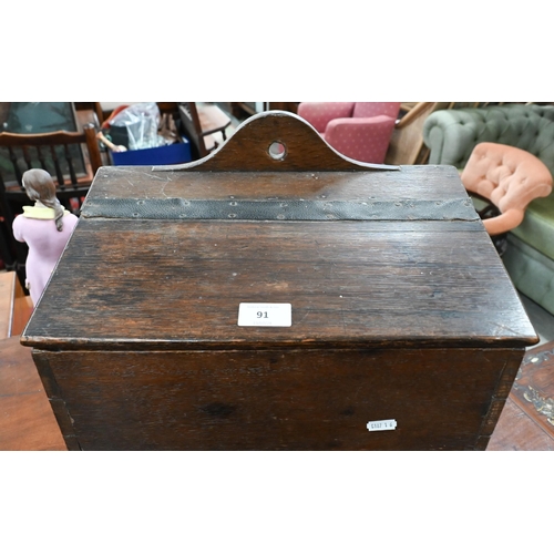 91 - An antique oak slopetop candle box, 38 x 22 x 28 cm high to/w an antique wooden pipe-rack carved wit... 