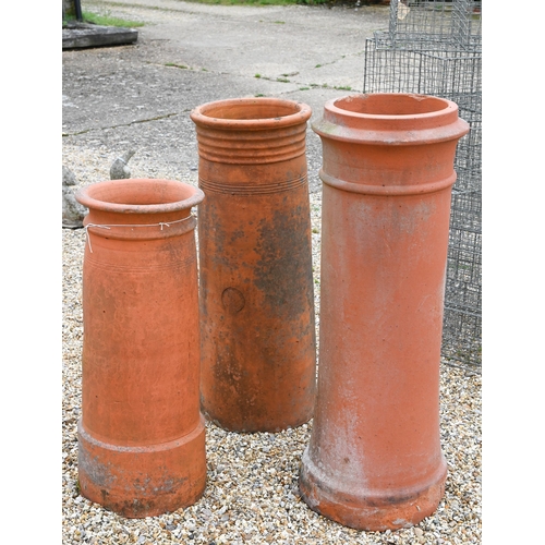 14 - A trio of tall cylindrical reclaimed and weathered terracotta chimney pots, 92 cm; 82 cm and 71 cm h... 