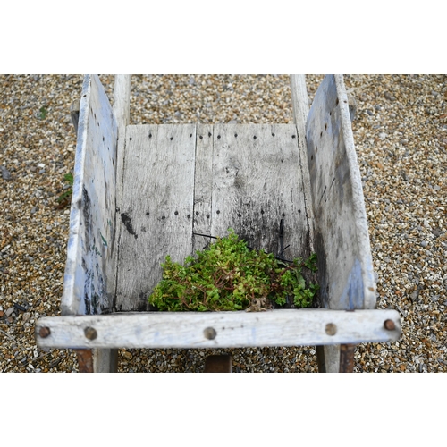 23 - A weathered vintage wooden wheelbarrow