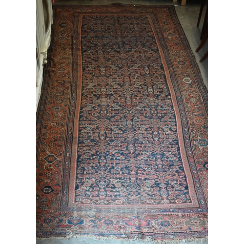 116 - A worn Persian Hamadan kelleigh carpet, Herati design on navy blue ground with terracotta border, 40... 