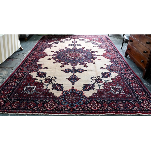 A North East Persian Meshed carpet, the camel ground centred with a blue medallion, 440 cm x 300 cm