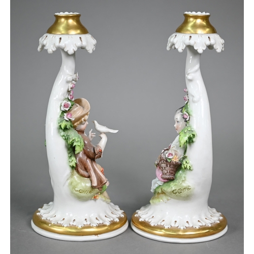 16 - A Continental porcelain floral-encrusted candelabrum with three sconces and dancing cherubs playing ... 