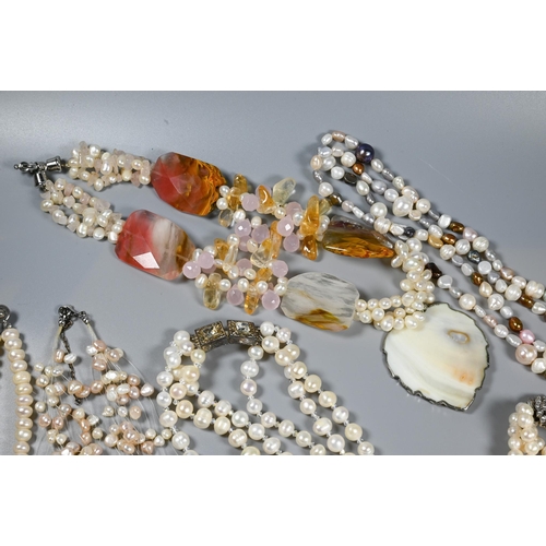 385 - A collection of cultured and simulated pearl necklaces, including pale pink, baroque, chokers, opera... 