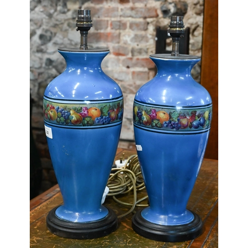 132 - AMENDED ESTIMATE A pair of blue-glazed ceramic table lamps printed with bands of fruit, 43 cm high o... 