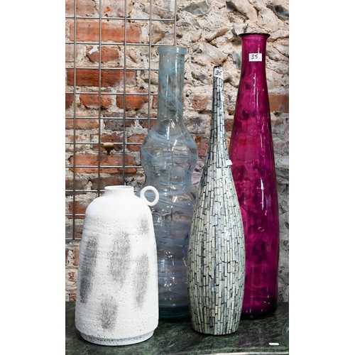 35 - A red glass carboy of cylindrical form, a green glass carboy, two tall glass vases, a ceramic vase w... 