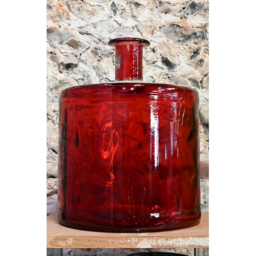 35 - A red glass carboy of cylindrical form, a green glass carboy, two tall glass vases, a ceramic vase w... 