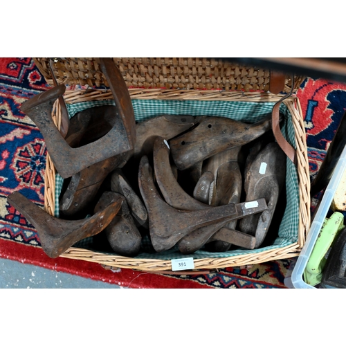 391 - A wicker basket containing a collection of antique cobbler's lasts, anvil and wooden lasts/forms to/... 